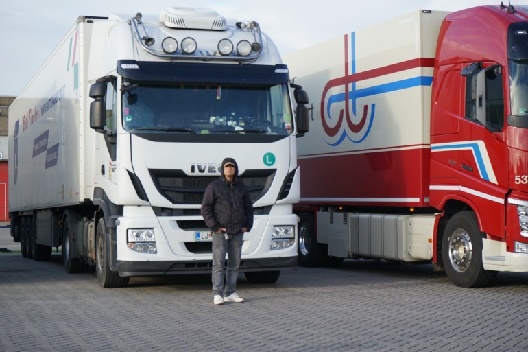 Truck driver Randy poses in front of a truck