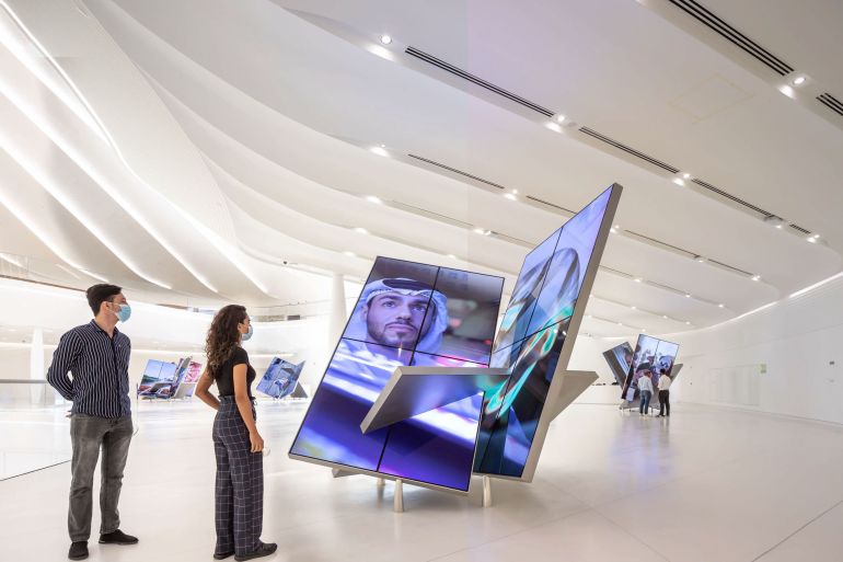 Visitors stand in front of an innovative screen inside the 'The Dreamers Who Do' section of the UAE Pavilion