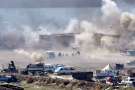People are seen fleeing as heavy smoke rises above the Islamic State (IS) group's last remaining position in the village of Baghouz