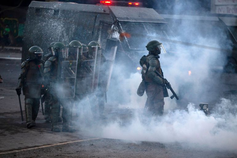 Riot police clash with demonstrators during a protest against Chilean President Sebastian Pinera's government