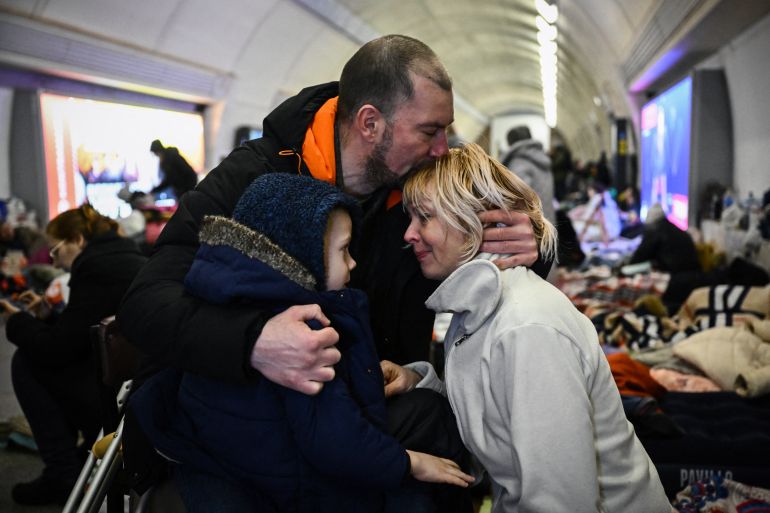 Sergyi Badylevych hugs his wife Natalia Badylevych and child in an underground metro station used as bomb shelter in Kyiv on March 2