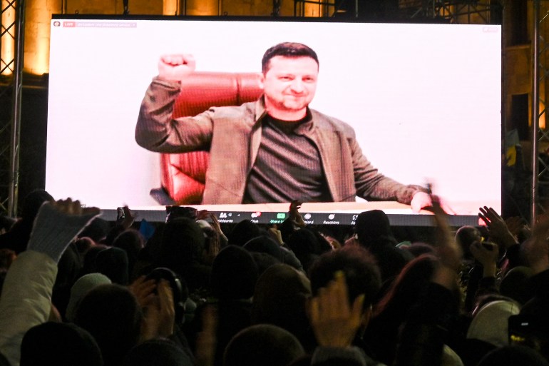 Ukrainian President Volodymyr Zelenskyy seen on a big screen