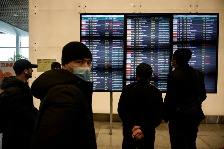 Passengers gather in front of a departures board at Moscow's Domodedovo airport - the base of Russian carrier S7 - on March 5, 2022, the day S7 Airlines cancelled all its international flights due to sanctions imposed on Russia over the country's invasion of Ukraine.