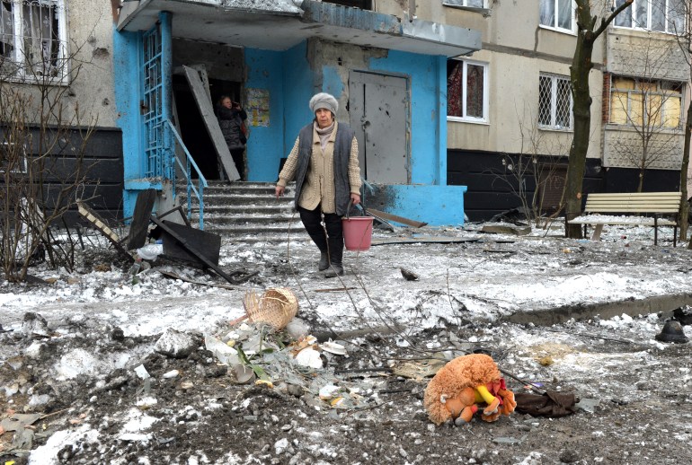 A woman carries a bucket following a shelling in Ukraine's second-biggest city of Kharkiv on March 7