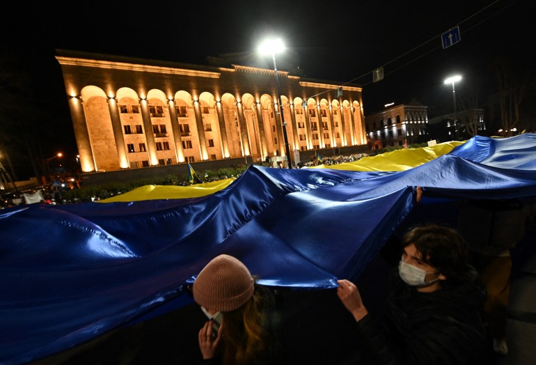 Protesters in Georgia wave a Ukrainian flag