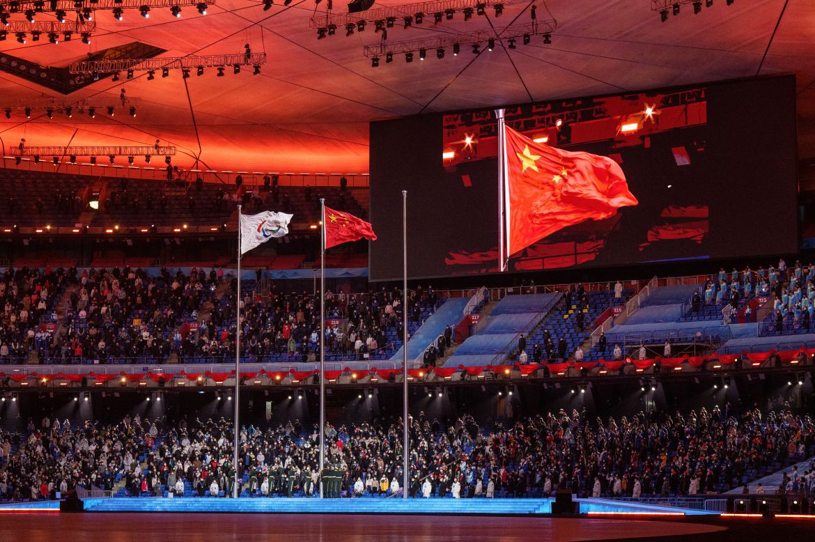 This handout photo taken and received from the OIS/IOC on March 13, 2022 shows the Paralympic flag (L) next to China's flag during the closing ceremony of the Beijing 2022 Winter Paralympic Games