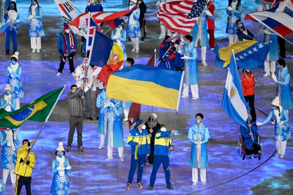 Flagbearer Ukraine's Vitalii Lukianenko (R) takes part in the closing ceremony of the Beijing 2022 Winter Paralympic Games at the National Stadium, known as the Bird's Nest, in Beijing