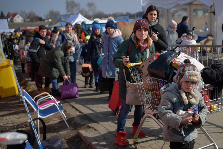 People walk to take further transportatipon after crossing the Ukrainian border into Poland 