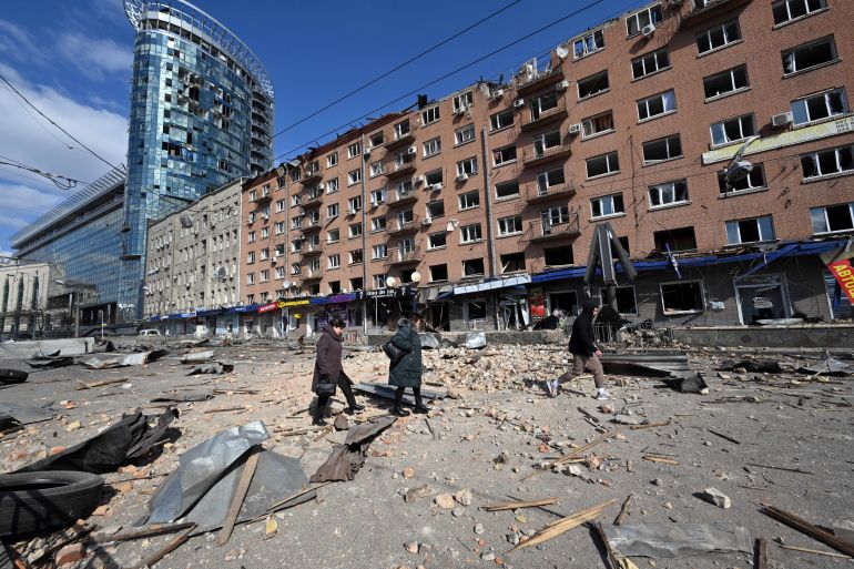 People walk by a building damaged by shelling amid Russian invasion of Ukraine in Kyiv