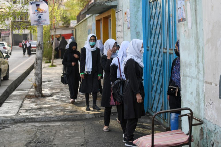 Girls arrive at their school in Kabul