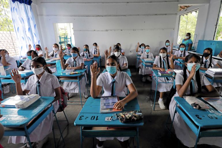 Students wearing protective face masks practice keeping a one meter distance as they attend a maths lesson inside a class room on the first day at Vidyakara college, which re-opened after almost two months of lock-down amidst concerns about the spread of coronavirus disease (COVID-19), in Colombo, Sri Lanka July 6, 2020.