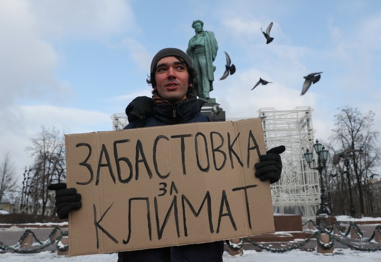 Climate activist Arshak Makichyan holds a cardboard reading "Strike for Climate" during a single-person demonstration in central Moscow, Russia