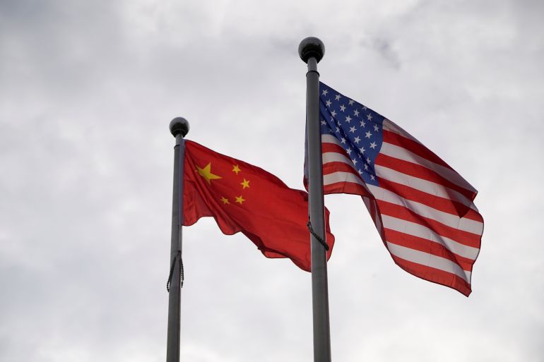 Chinese and U.S. flags flutter outside a company building in Shanghai, China