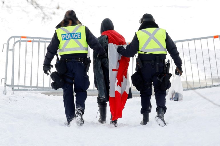 A man is escorted by police in Ottawa, Canada