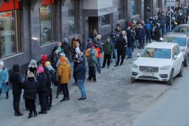 People stand in line to use an ATM money machine in Saint Petersburg, Russia.