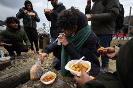 Yemeni men eat after crossing the border between Poland and Ukraine