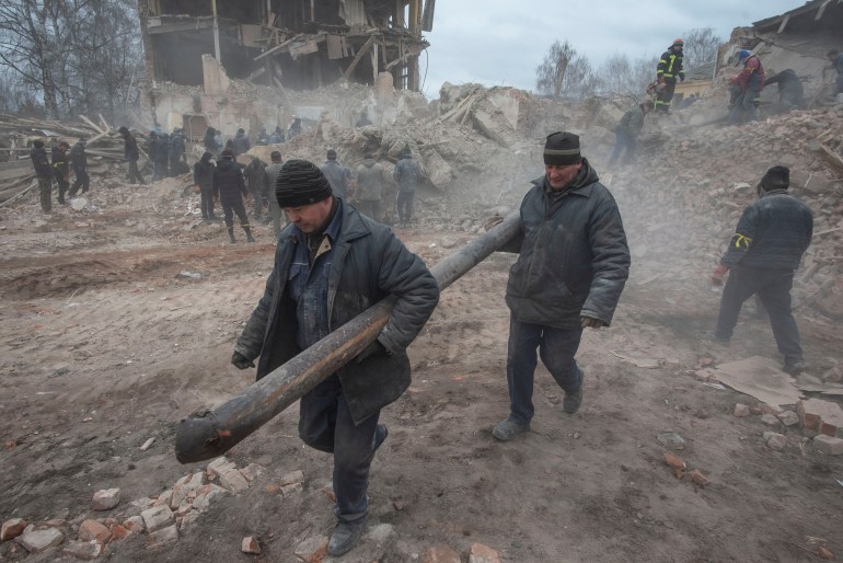 People are seen removing debris in Okhtyrka