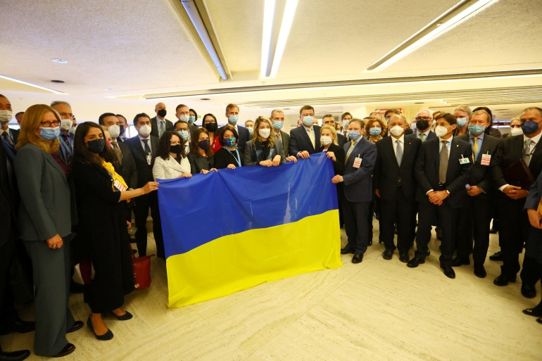 Melanie Joly, Minister of Foreign Affairs of Canada, Ukraine's ambassador Yevheniia Filipenko and other delegates gather with a Ukrainian flag after walking out of the Human Rights Council meeting during the video speech by Russian Foreign Minister Sergei Lavrov at the United Nations in Geneva, Switzerland, March 1, 2022. 