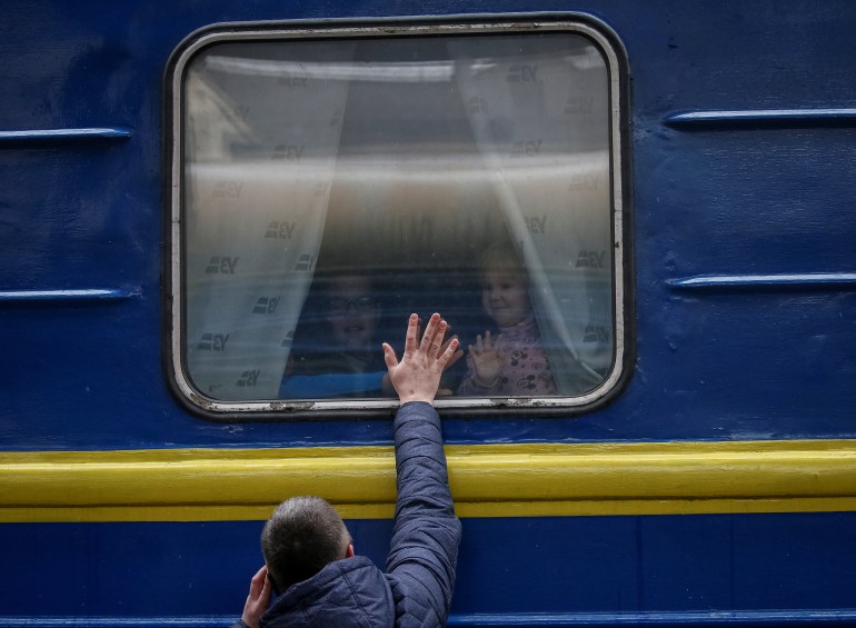 Children are seen looking out from an evacuation train from Kyiv to Lviv