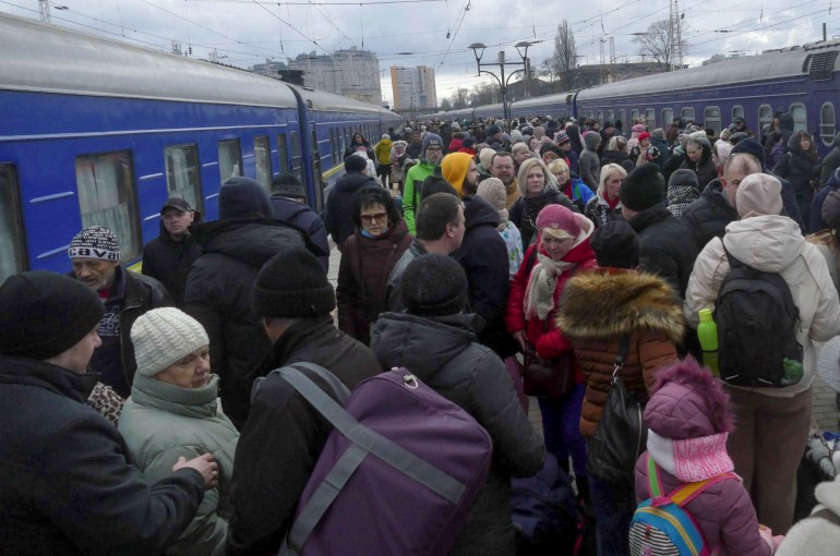 People fleeing Russia's invasion of Ukraine crowd on a platform to board a train as they leave the city of Odesa.