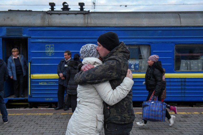 A couple is seen embracing as people fleeing Russia's invasion board a train in Odesa