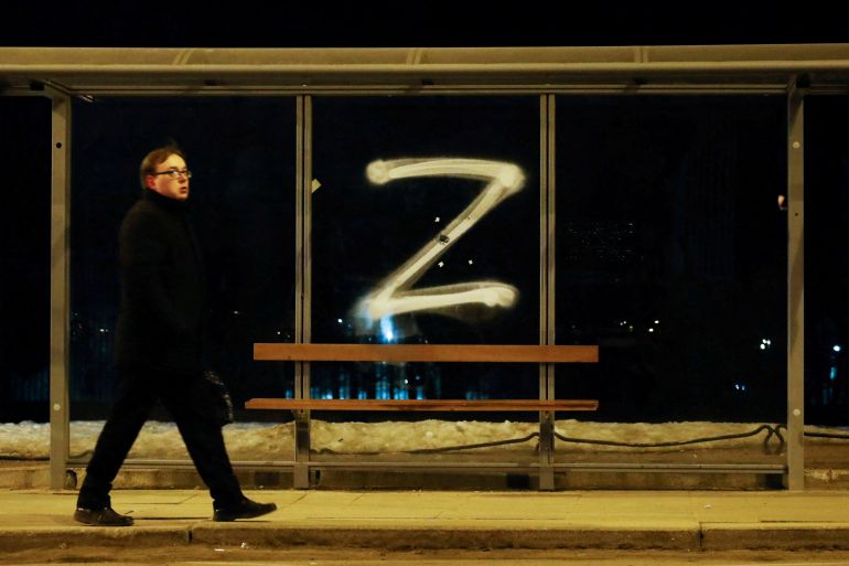 A man walks past the symbol "Z" painted on a bus stop in support of the Russian armed forces