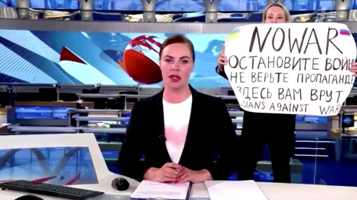 A person interrupts a live news bulletin on Russia's state TV "Channel One" holding up a sign that reads "NO WAR. Stop the war.