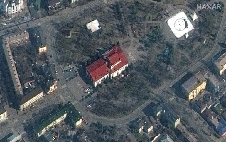 A satellite image shows a closer view of the Mariupol Drama Theatre before bombing, as the word "children" in Russian is written in large white letters on the pavement in front of and behind the building, in Mariupol, Ukraine, March 14, 2022.
