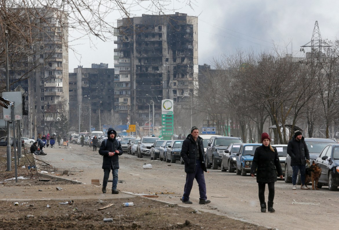 A view shows people and a line of cars near blocks of flats destroyed during Ukraine-Russia conflict, as evacuees leave the besieged southern port city of Mariupol,