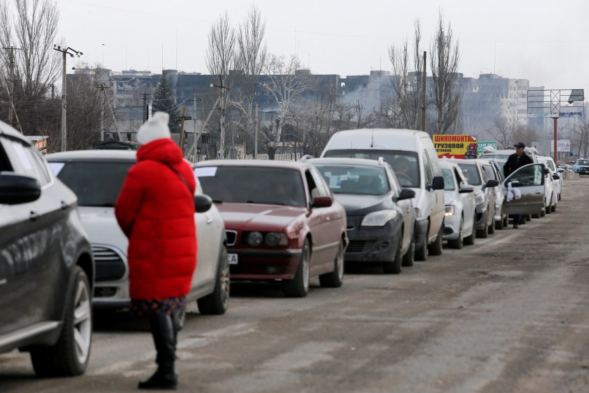 A view shows a line of cars near blocks of flats destroyed during Ukraine-Russia conflict, as evacuees leave the besieged southern port city of Mariupol