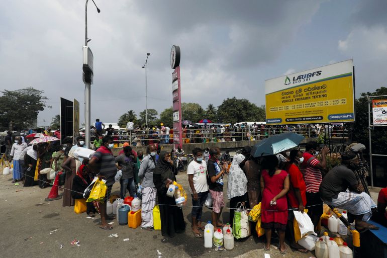 People stand in a long queue to buy kerosene