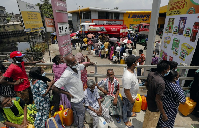 People stand in a long queue to buy kerosene oil in Sri Lanka