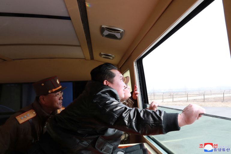 North Korean leader Kim Jong Un looks through a window during the test firing of what state media report is a "new type" of intercontinental ballistic missile