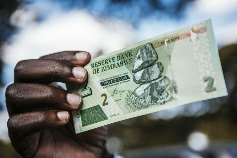 A man holds a Zimbabwean two-dollar bond banknote
