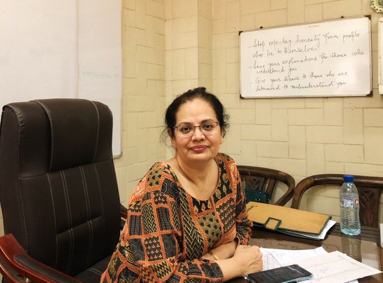 A photo of Dr Summaiya with a whiteboard with some writing on it behind her.