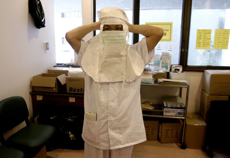 Eric Wong, a 42-year-old nurse at the intensive care unit of the Prince of Wales Hospital in Hong Kong Tuesday, May 13, 2003, puts on a hood with an attached surgical mask as part of his protective gear before entering a ward where the sickest SARS patients are treated. Nurses are at greater risk than anyone else from getting infected by the flu-like disease as they are often in close contact with patients and perform some high-risk procedures. Wong said he was very frightened of getting infected when an outbreak of severe acute respiratory syndrome first began at the hospital, but he has stayed healthy.