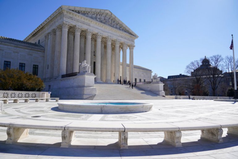 People stand on the steps of the U.S. Supreme Court.