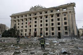 A member of the Ukrainian Emergency Service looks at the City Hall building in the central square following shelling in Kharkiv, Ukraine, Tuesday, March 1, 2022. (AP Photo/Pavel Dorogoy)