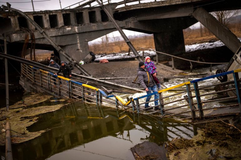 Ukrainian family crosses destroyed brigde