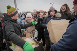 Volunteers give food and drinks to people, at the border crossing in Medyka, Poland