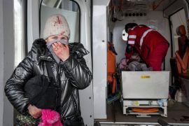 A woman reacts as paramedics perform CPR on a girl who was injured during shelling, at city hospital of Mariupol