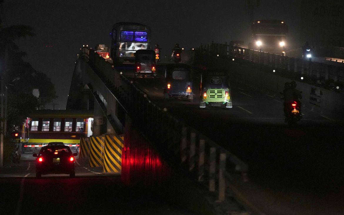 A train and vehicles roll in the dark during a power cut in Kelaniya