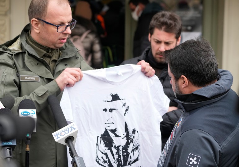 The Mayor of Przemysl, Wojciech Bakun, left, holds up a t-shirt with the likeness of Russian President Vladimir Putin as Italy's League Party leader