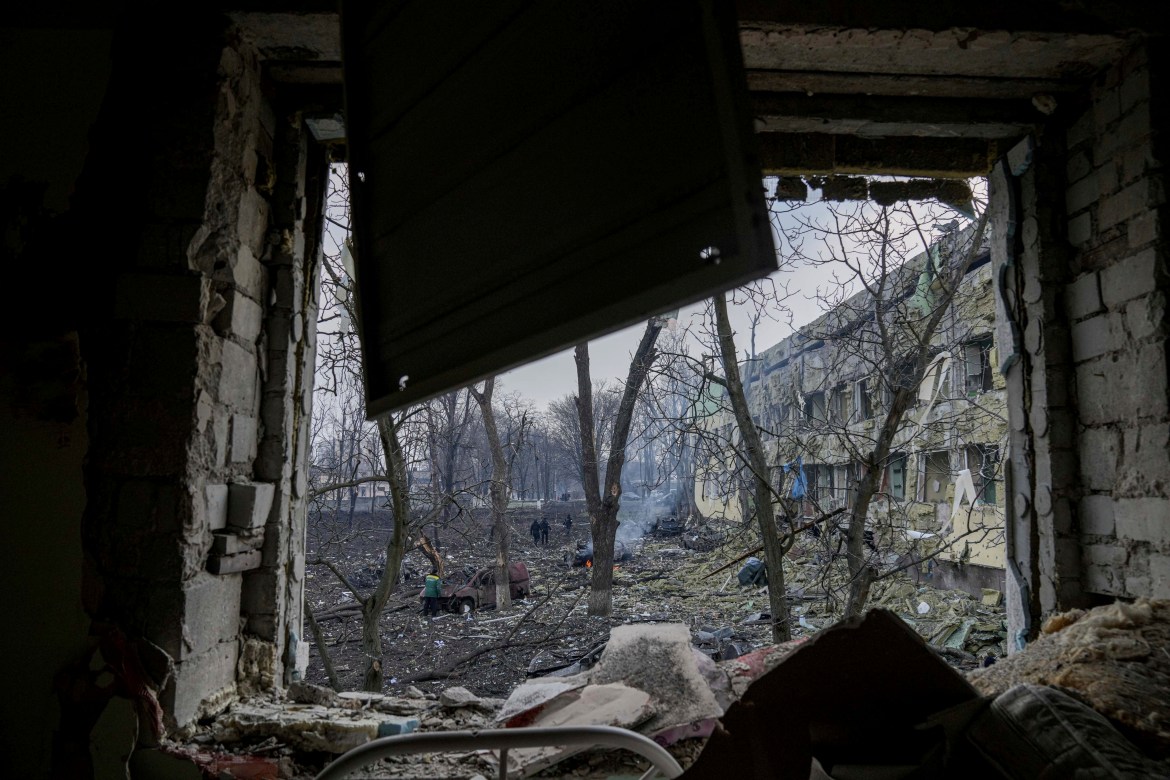 Ukrainian emergency employees work at the side of the damaged by shelling maternity hospital in Mariup