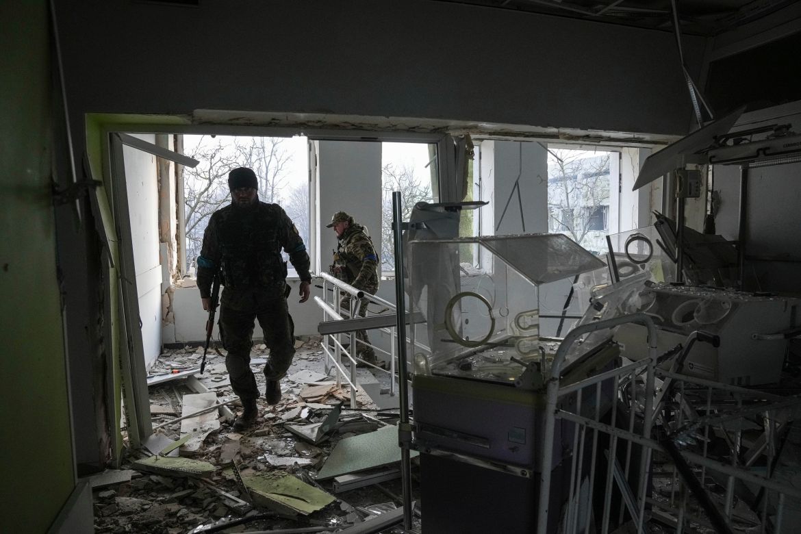 Ukrainian servicemen work inside of the damaged by shelling