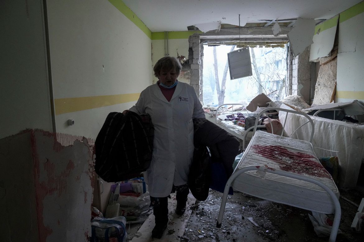 A medical worker walks inside of the damaged by shelling maternity