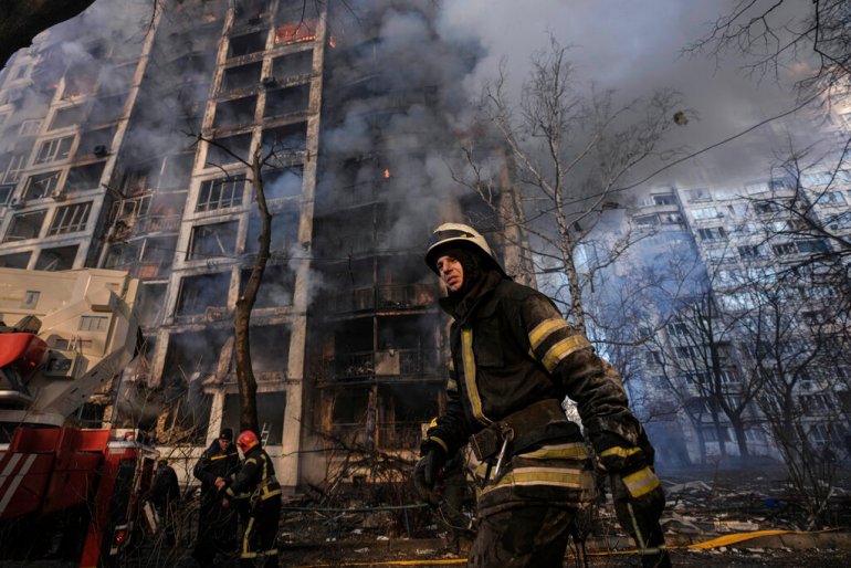 A firefighter walks outside a destroyed apartment building after a bombing in a residential area in Kyiv, Ukraine.