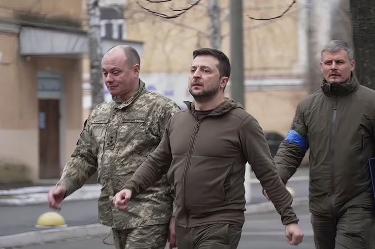 In this image from video provided by the Ukrainian Presidential Press Office and posted on Facebook on Sunday, March 13, 2022, Ukrainian President Volodymyr Zelenskyy walks to a hospital to visit doctors, nurses and wounded military members in Kyiv, Ukraine. (Ukrainian Presidential Press Office via AP)