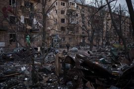 A police officer walks at the site of a bombing that damaged residential buildings in Kyiv