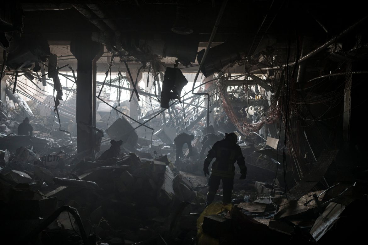 Ukrainian firefighters and servicemen search for people under debri